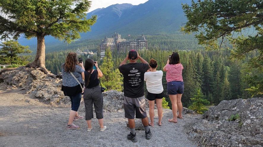 Two people in winter clothing with snowy mountains in the background.